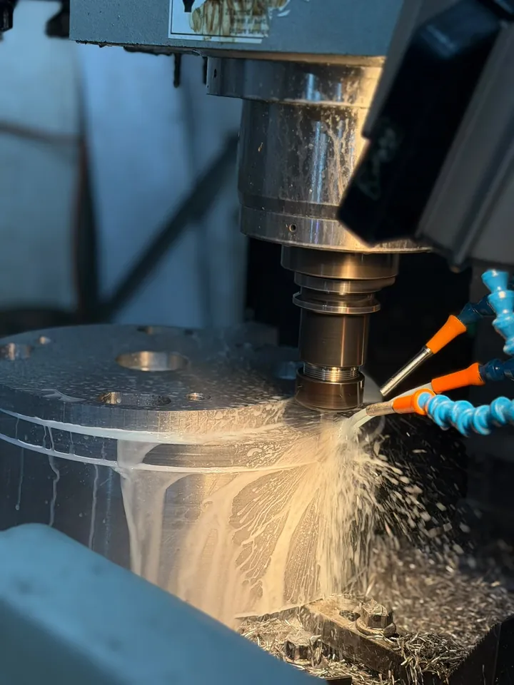 Close view of a CNC milling cut with coolant spray and swarf