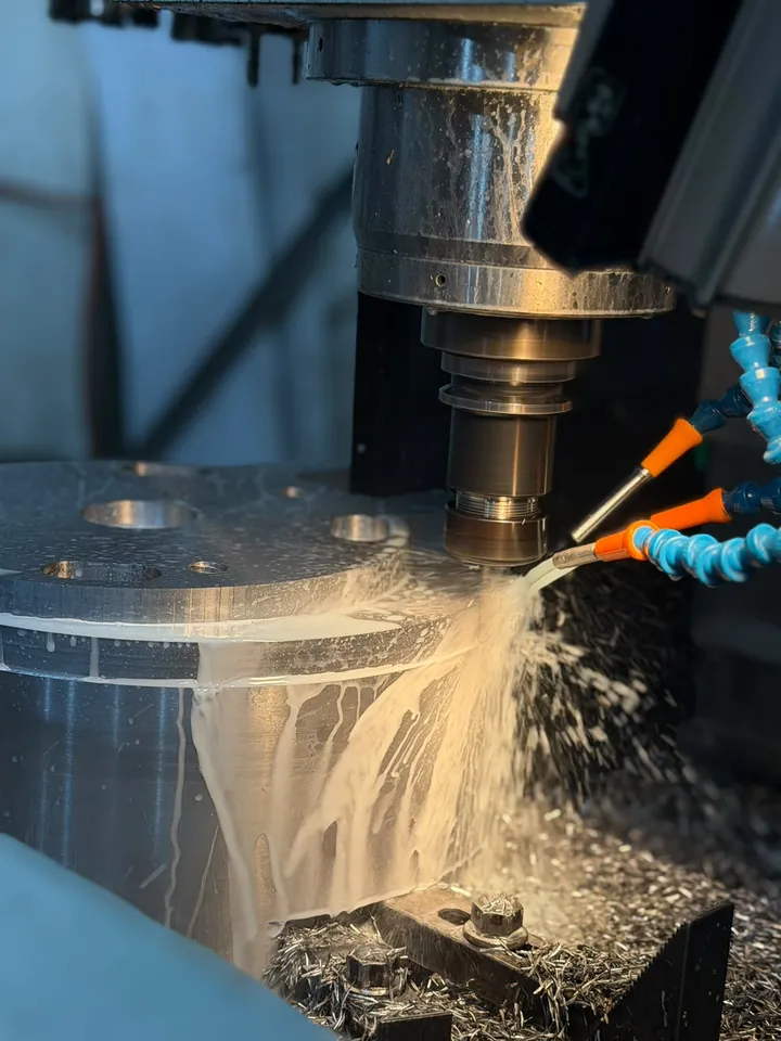 CNC spindle milling a bored part with coolant flowing over it